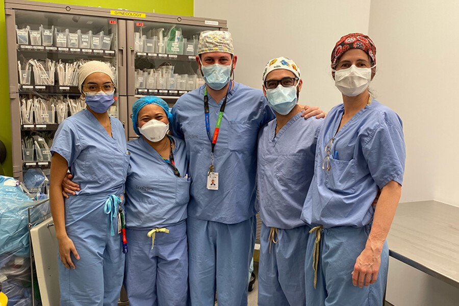 The medical team poses in scrubs after surgery
