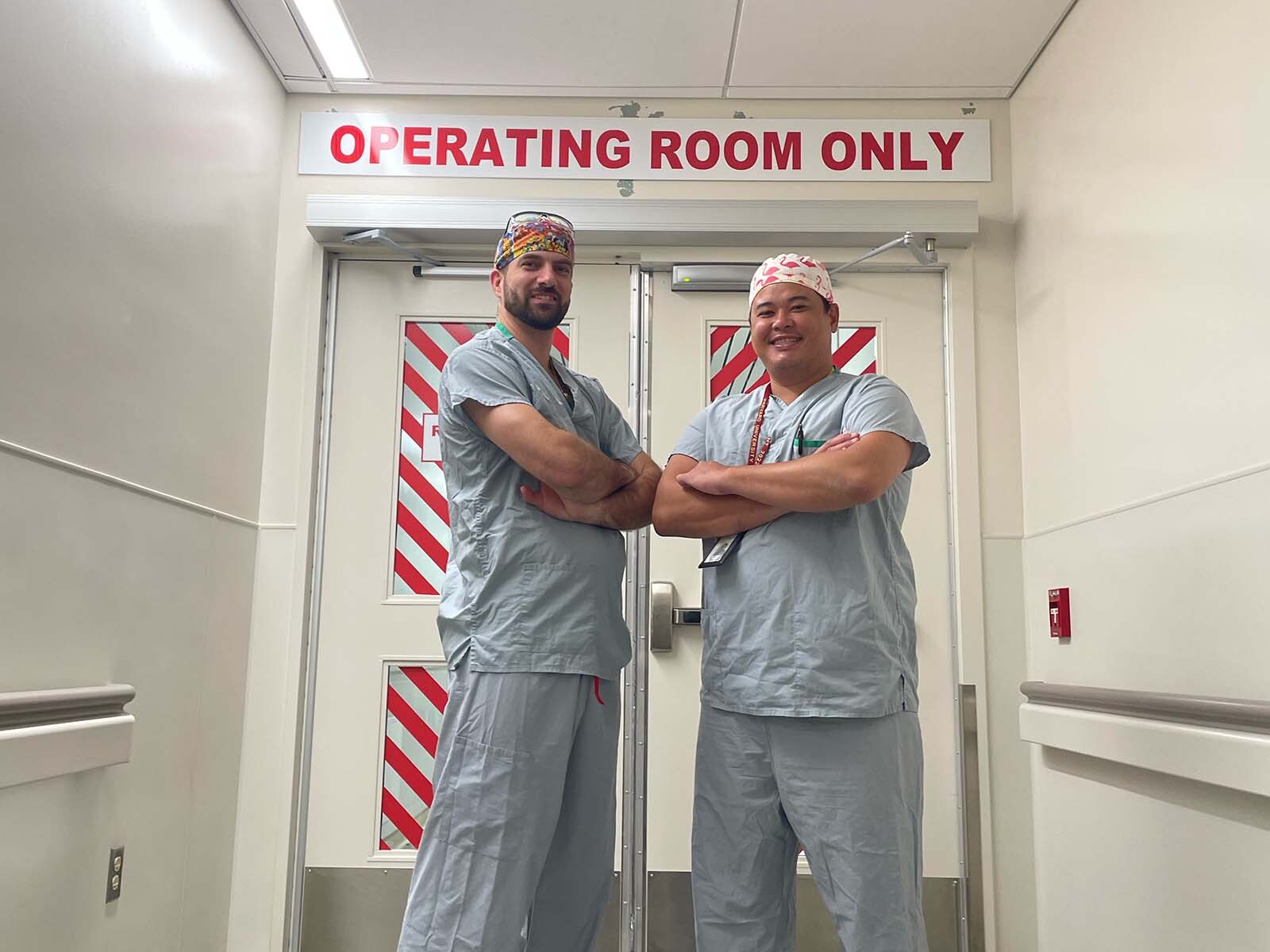 Darl Edwards and Wilson Chan stand outside the operating room